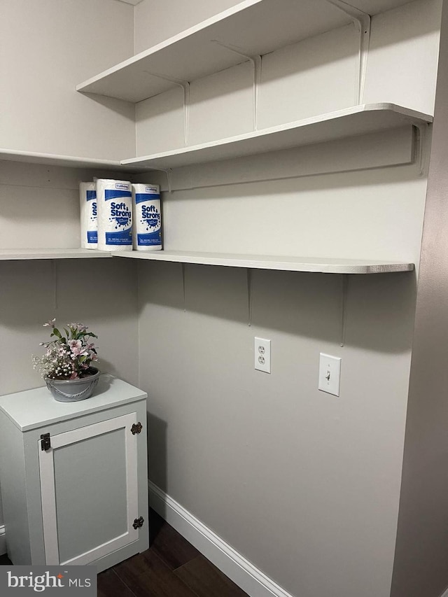 laundry room with baseboards and dark wood-style flooring