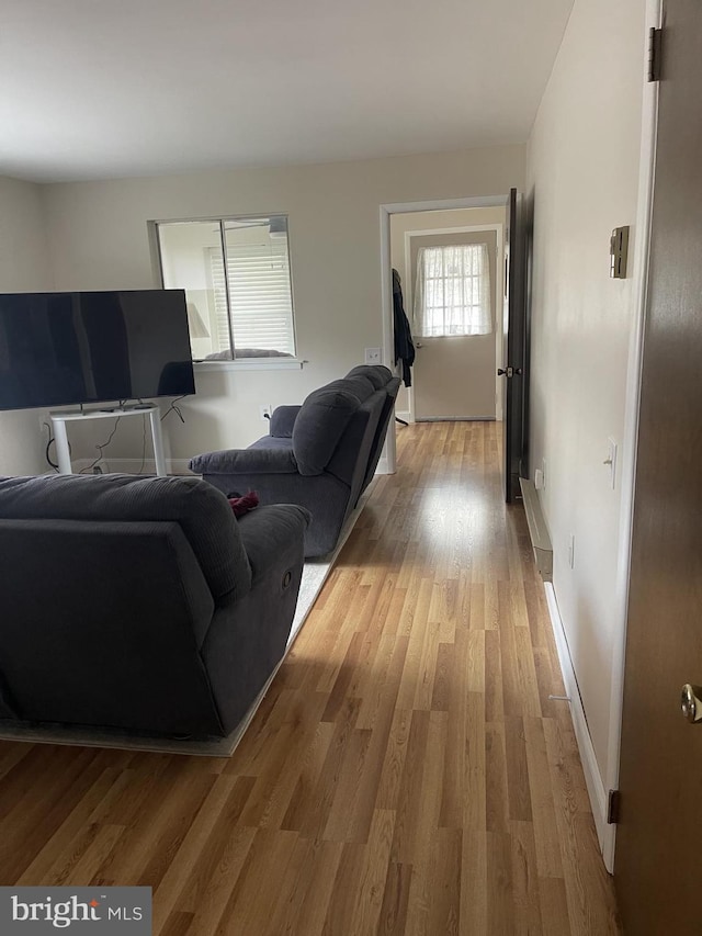 living room with light wood-type flooring and baseboards