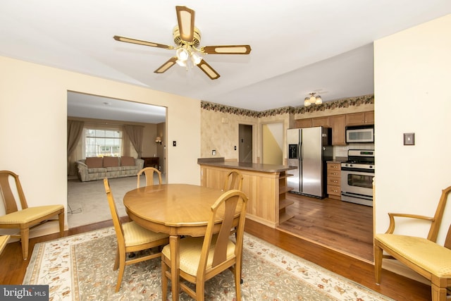 dining area featuring lofted ceiling, ceiling fan, and wood finished floors