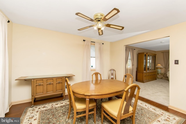 dining room featuring a ceiling fan, baseboards, and wood finished floors