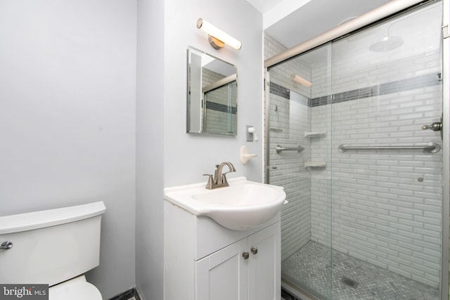 full bathroom with a stall shower, vanity, and toilet