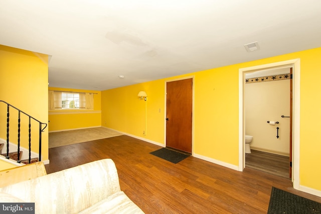 living room with baseboards, stairway, and wood finished floors