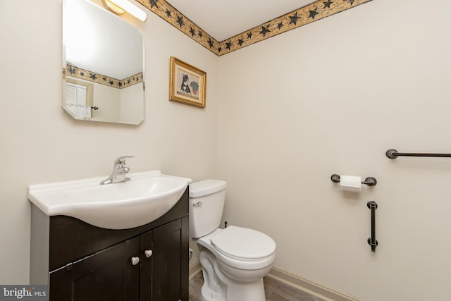 bathroom featuring vanity, toilet, and baseboards