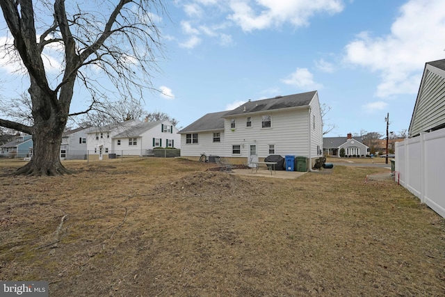 rear view of property with a yard, a residential view, fence, and a patio