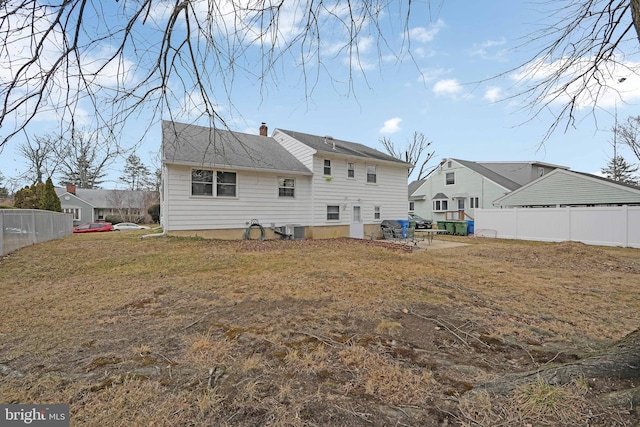 back of property featuring central AC, fence, and a chimney