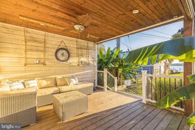 wooden terrace with a ceiling fan and outdoor lounge area