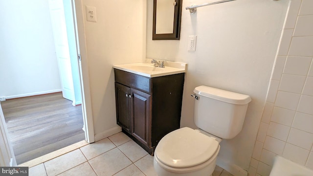 full bath with baseboards, toilet, tile patterned flooring, walk in shower, and vanity