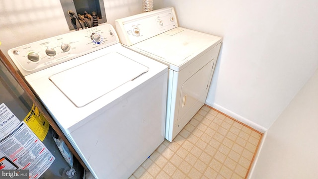 washroom with light floors, washing machine and dryer, laundry area, and baseboards