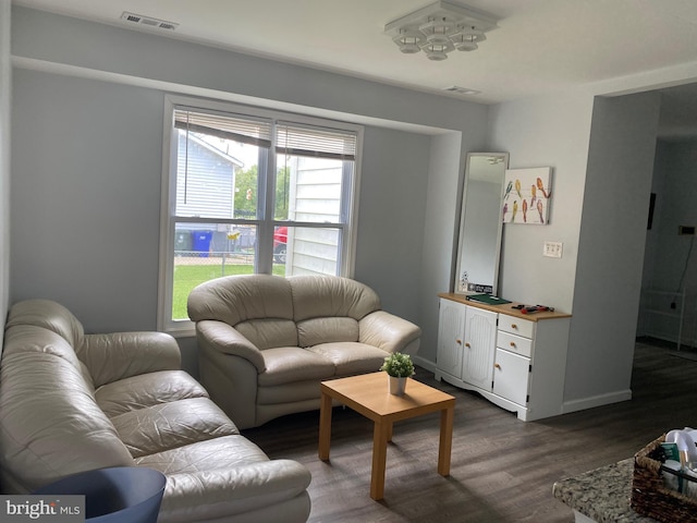 living room with baseboards, visible vents, and dark wood-type flooring