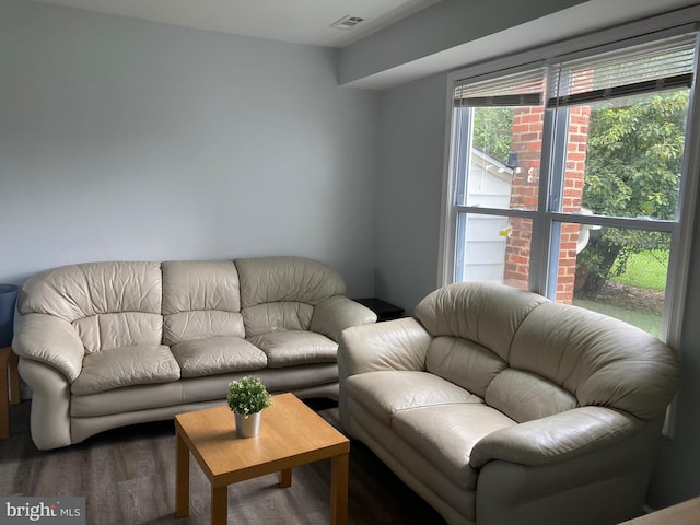 living area featuring visible vents and wood finished floors