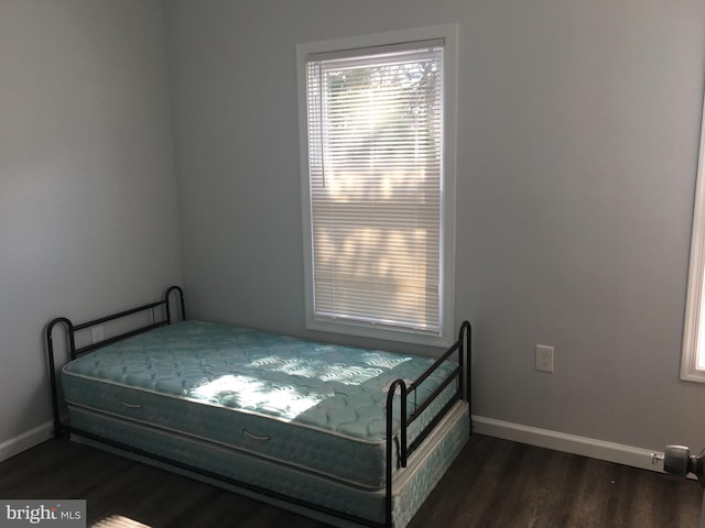 bedroom with baseboards and dark wood finished floors