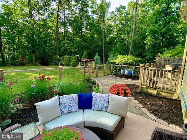 view of patio with a trampoline, outdoor lounge area, and fence