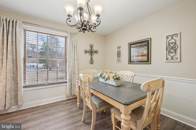 dining space with an inviting chandelier, wood finished floors, and baseboards