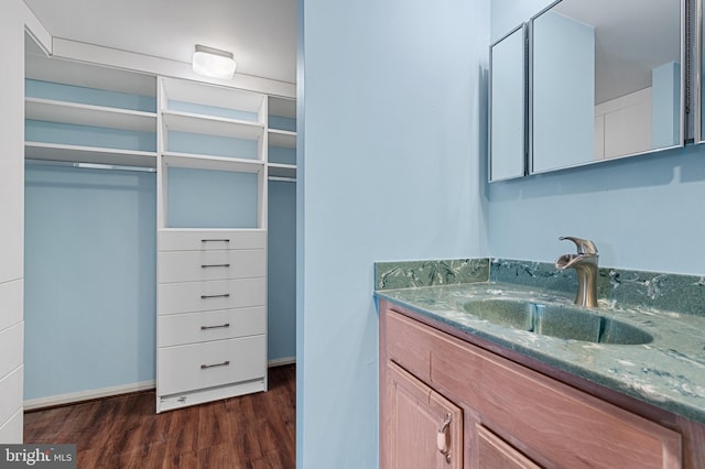 bathroom with wood finished floors, vanity, and baseboards