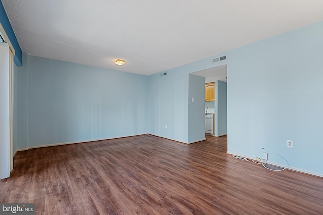 spare room with dark wood-style floors and visible vents