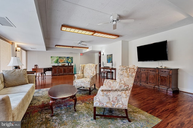 living room featuring baseboards, wood finished floors, visible vents, and a ceiling fan