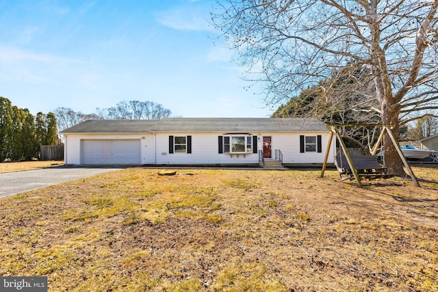 ranch-style house featuring a garage, aphalt driveway, fence, and entry steps