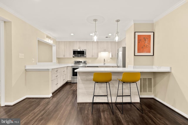 kitchen featuring a kitchen bar, dark wood-type flooring, stainless steel appliances, a peninsula, and crown molding