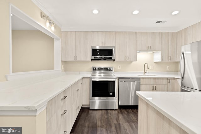 kitchen featuring visible vents, light brown cabinets, light stone counters, a sink, and stainless steel appliances