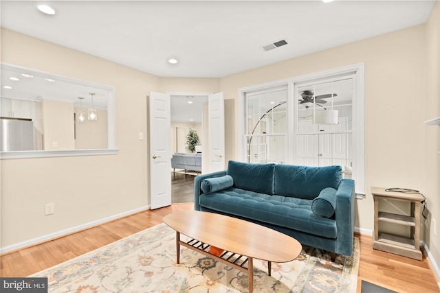 living area with recessed lighting, wood finished floors, visible vents, and baseboards