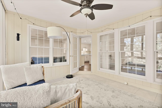 sunroom / solarium featuring a ceiling fan