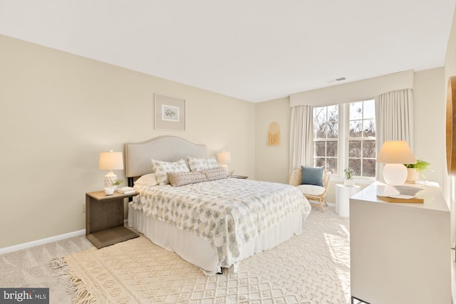 bedroom featuring light colored carpet and baseboards