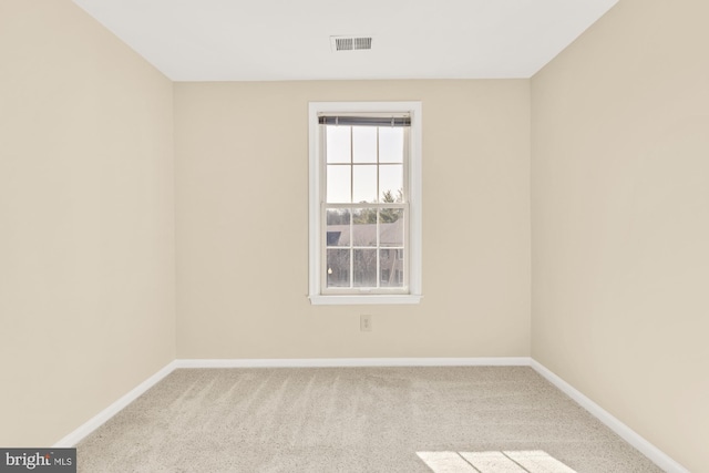 carpeted empty room featuring visible vents and baseboards