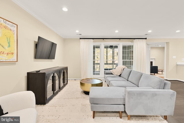 living room with wood finished floors, recessed lighting, baseboards, and ornamental molding