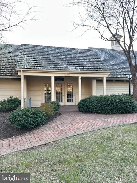 back of property with french doors and a chimney