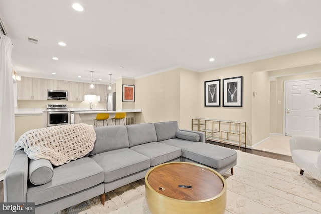 living room featuring recessed lighting, light wood-style flooring, baseboards, and ornamental molding