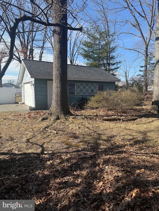 view of property exterior featuring an outbuilding and fence