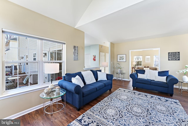 living room with lofted ceiling, baseboards, wood finished floors, and a healthy amount of sunlight