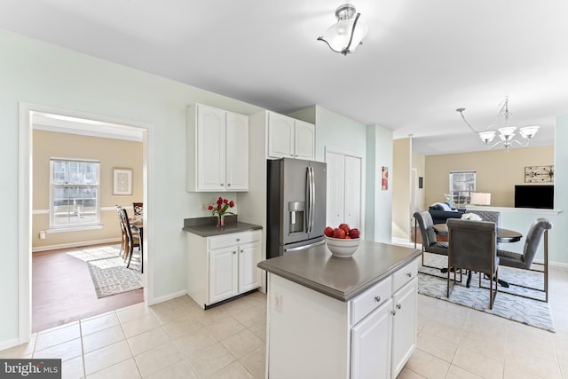 kitchen featuring dark countertops, white cabinetry, plenty of natural light, and stainless steel refrigerator with ice dispenser