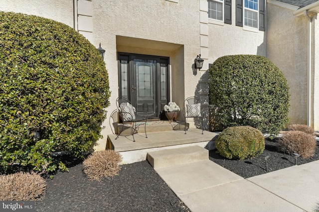 doorway to property featuring stucco siding