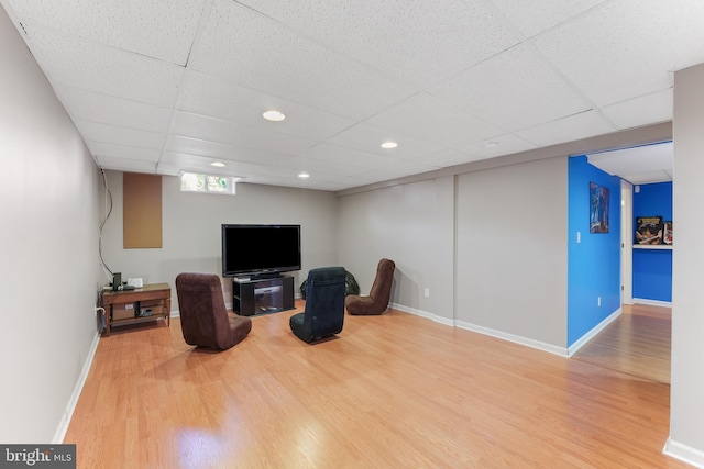 sitting room with recessed lighting, wood finished floors, a paneled ceiling, and baseboards