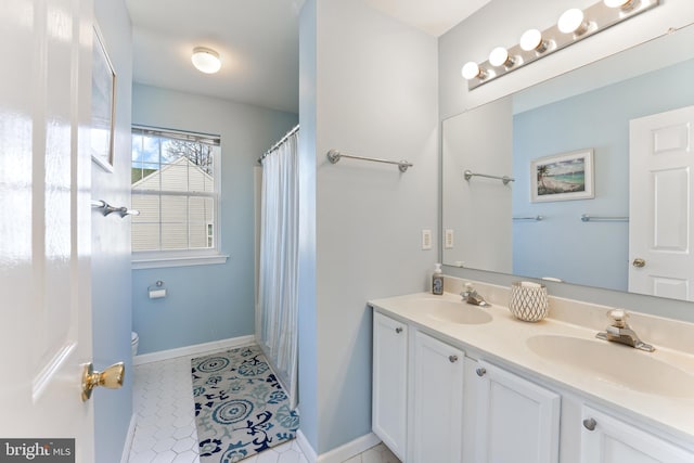 bathroom featuring toilet, tile patterned flooring, double vanity, and a sink