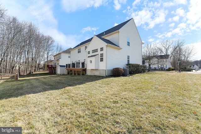 view of side of home with central AC unit and a lawn