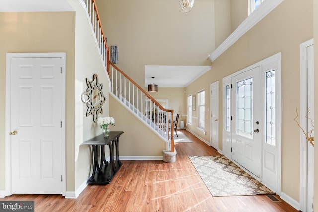 foyer with baseboards, stairway, and wood finished floors