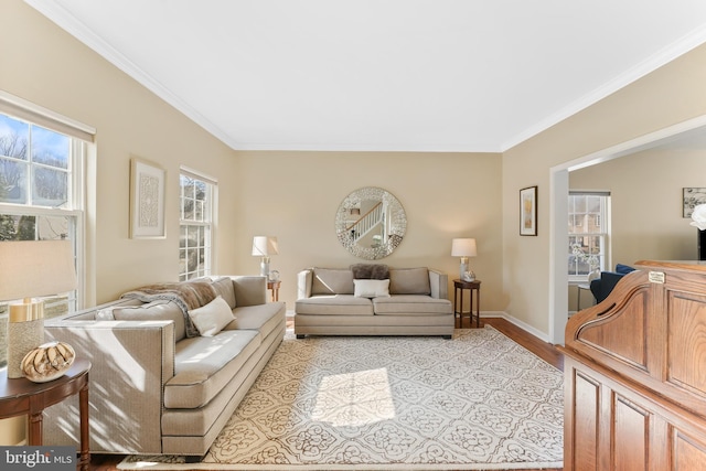 living area with light wood-style floors, crown molding, and baseboards