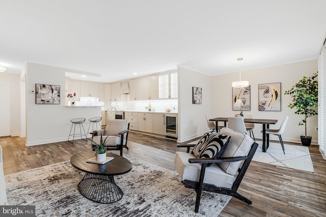 living room with wine cooler, wood finished floors, and baseboards