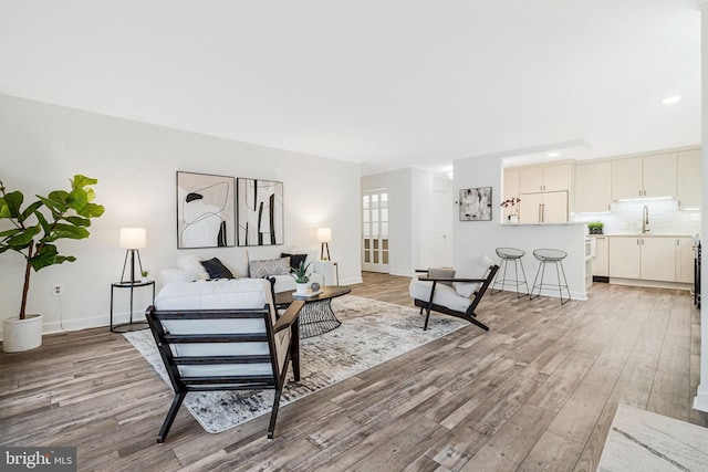 living area featuring recessed lighting, light wood-type flooring, and baseboards