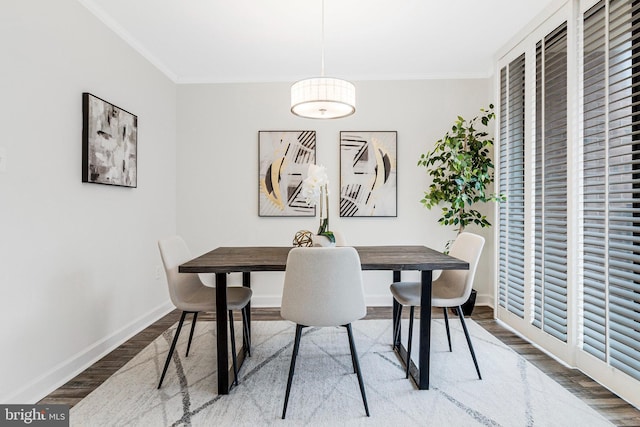 dining room featuring baseboards, ornamental molding, and wood finished floors