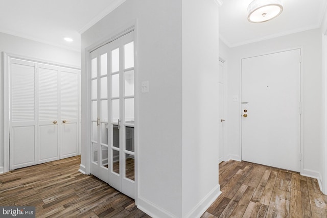 foyer entrance featuring baseboards, ornamental molding, and wood finished floors