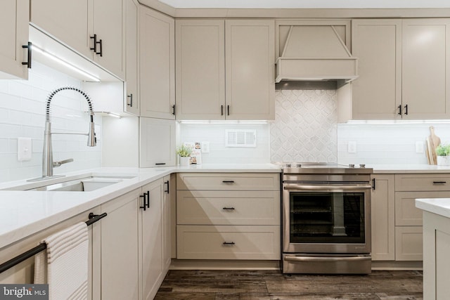 kitchen with dark wood finished floors, premium range hood, a sink, and stainless steel electric range