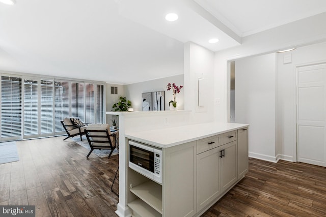 kitchen featuring dark wood finished floors, open shelves, recessed lighting, light countertops, and white microwave