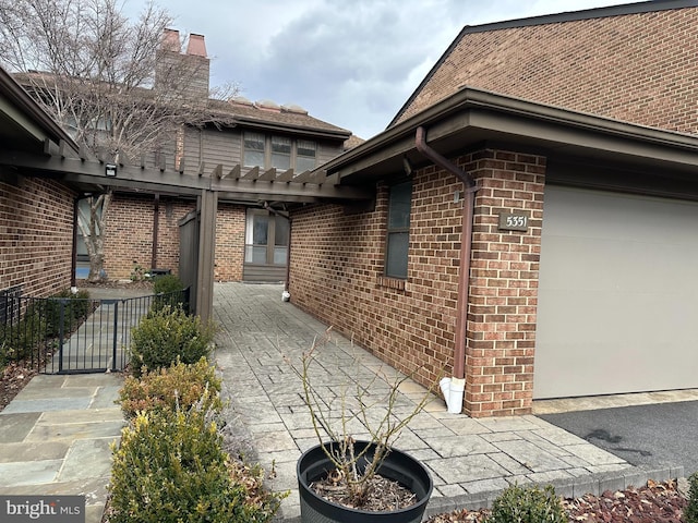 entrance to property featuring brick siding and an attached garage