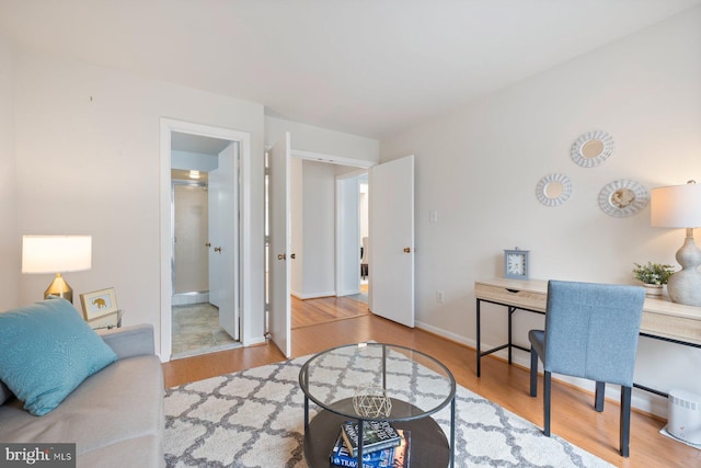 home office with baseboards and wood finished floors