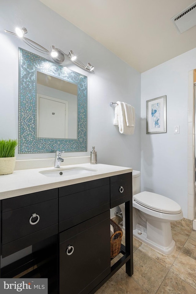 bathroom with vanity, toilet, and visible vents