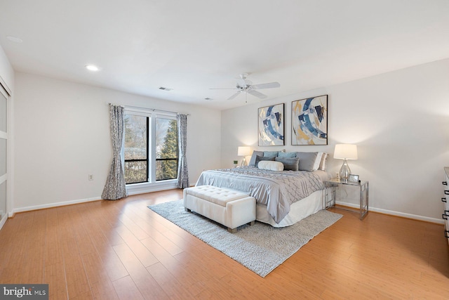 bedroom featuring light wood-type flooring, baseboards, visible vents, and a ceiling fan