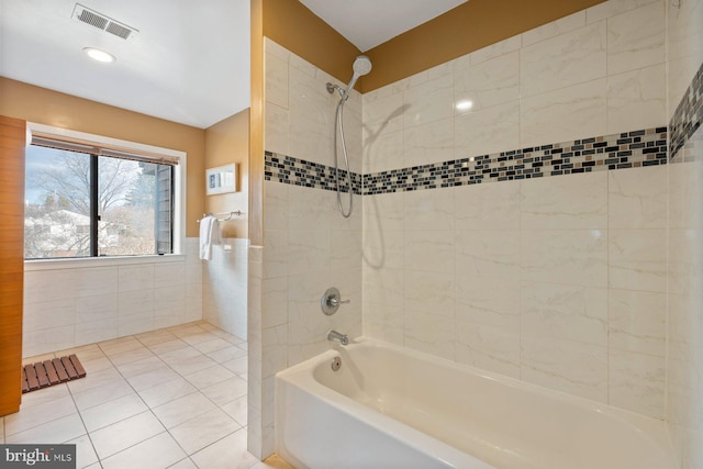 full bathroom featuring tile patterned flooring, visible vents, tile walls, and shower / tub combination